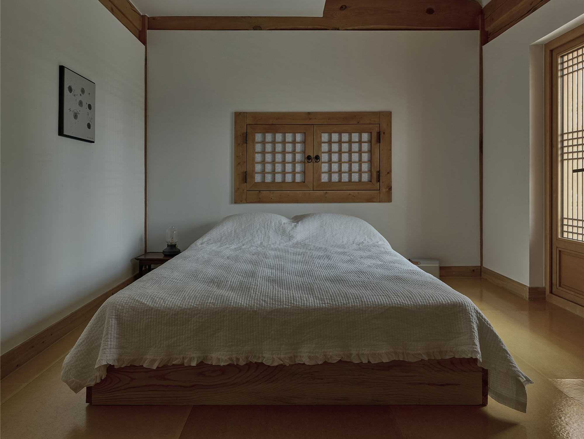 An ondol bedroom with a bed placed under a low window