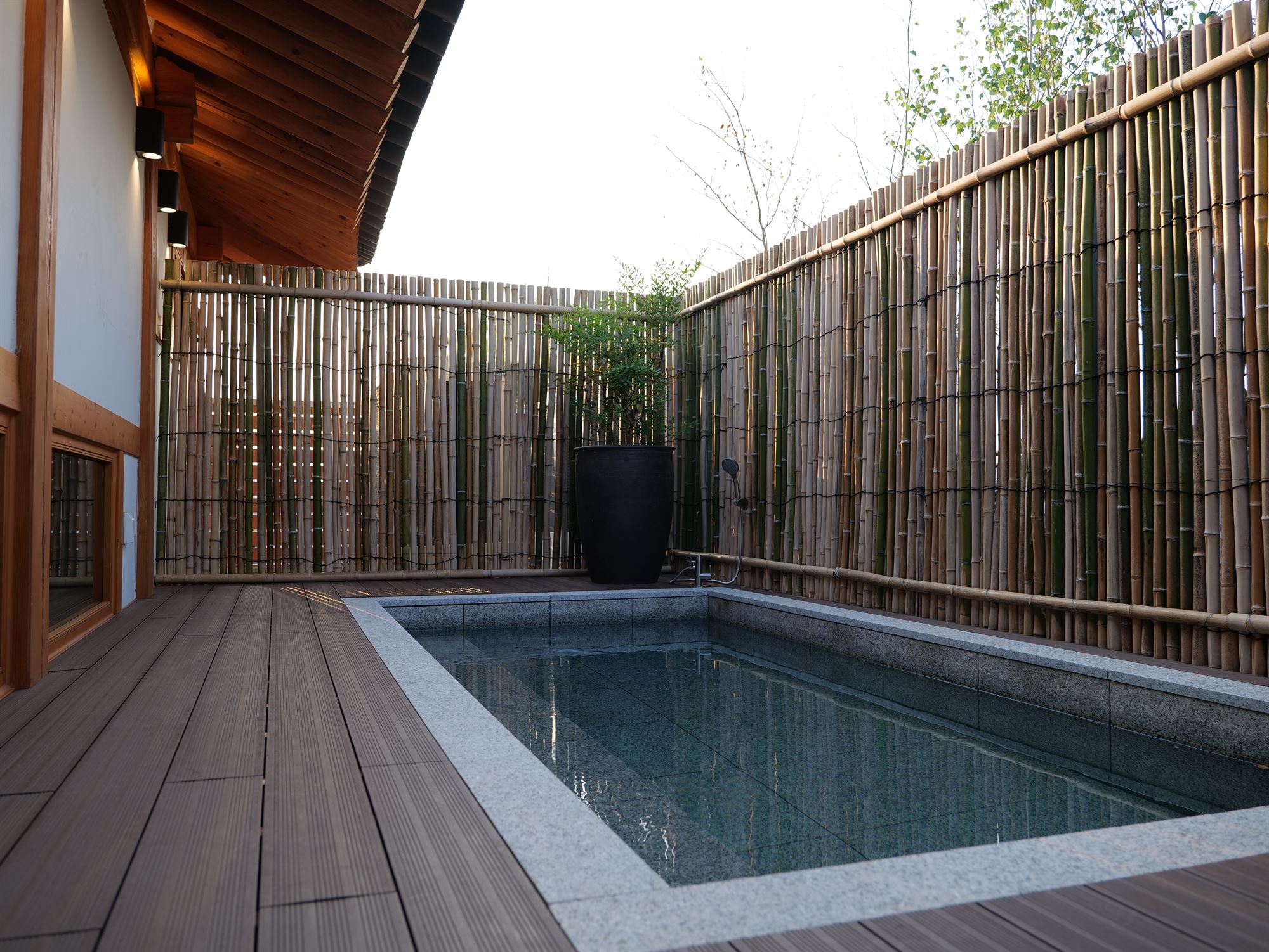 A private outdoor spa enclosed by a bamboo wall