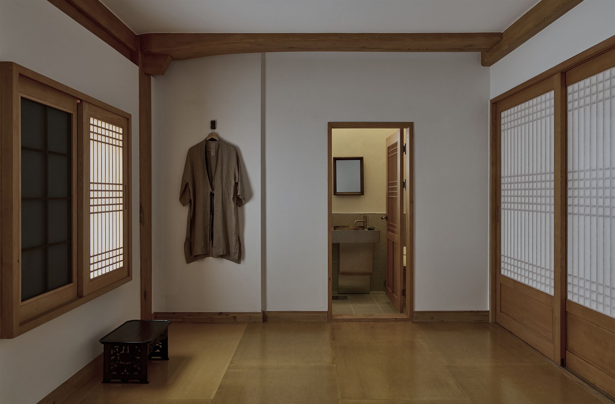 A vanity area connecting to the room where bathrobes hang