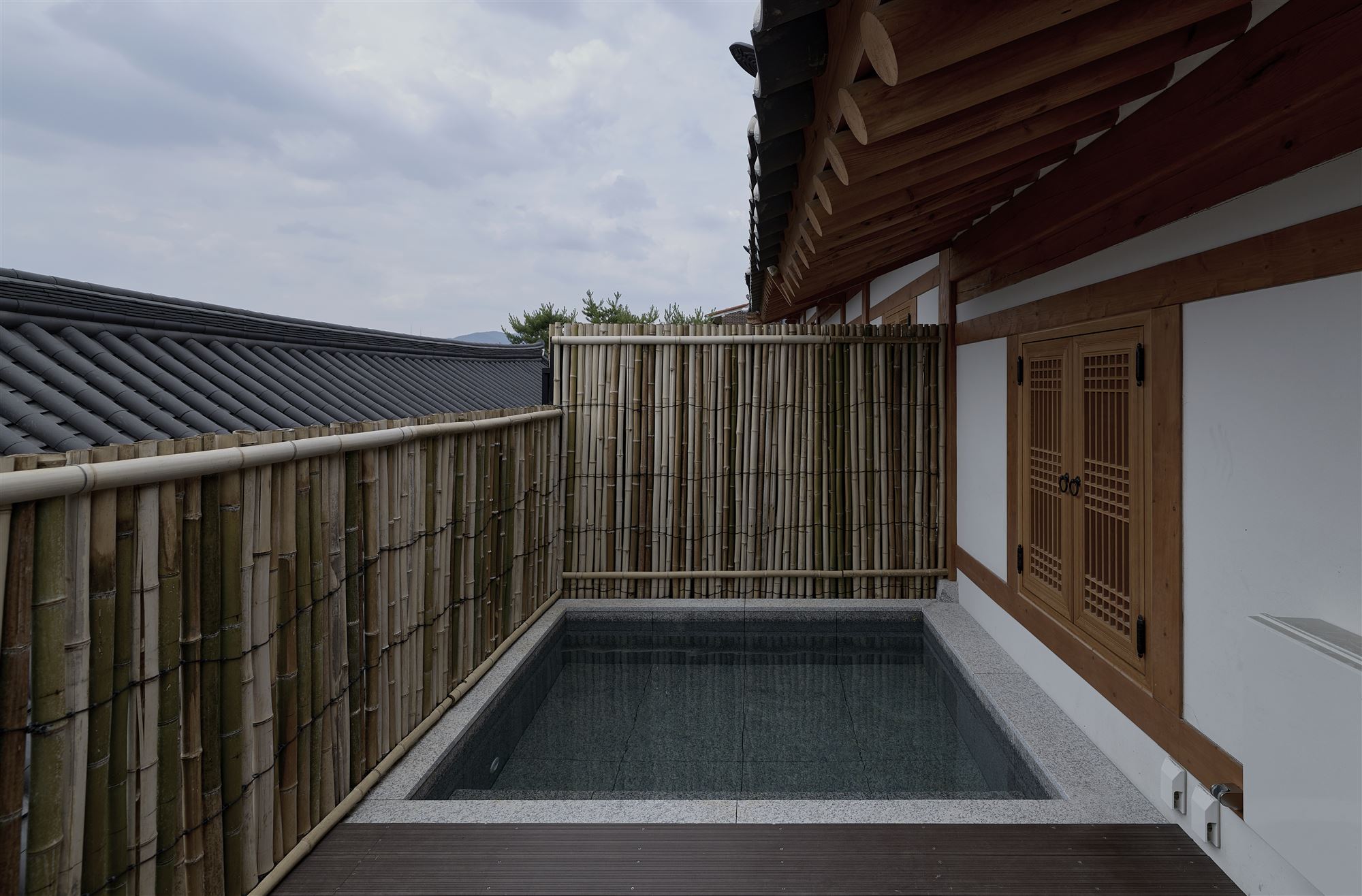 A private outdoor spa beneath the bamboo fence and tiled roof