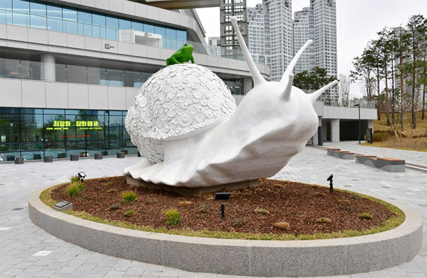 A large white snail public art sculpture installed in the plaza of Suwon Convention Center