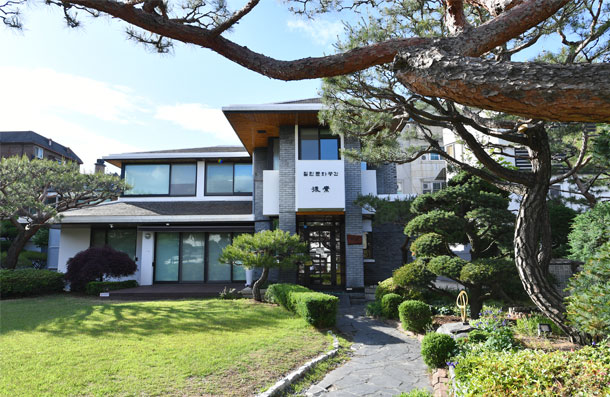 Exterior view of the open cultural space Huso, seen through pine trees