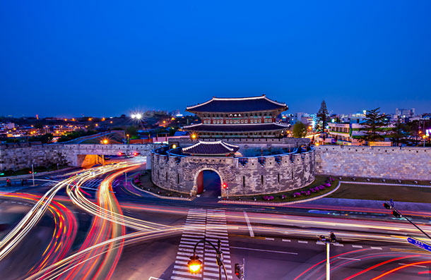 Night view of Janganmun gate and its semicircular wall with light trails from passing cars