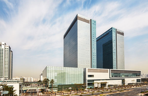 Exterior view of the glass curtain wall of Samsung Innovation Museum, with high-rise office buildings in the background