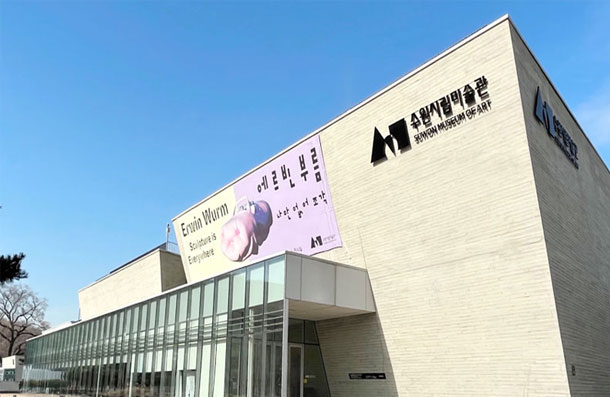 Exterior view and entrance of Suwon Museum of Art with exhibition banners hanging