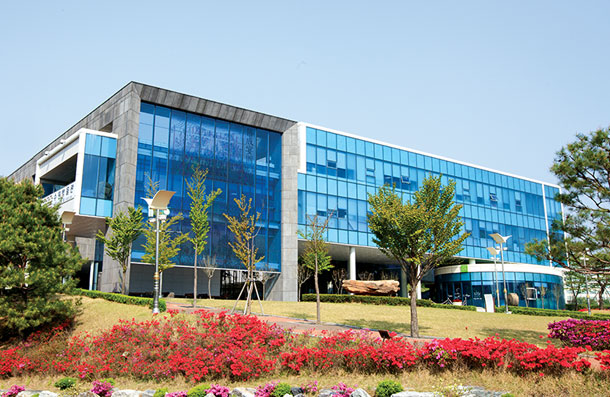 Exterior view of the main building of Suwon Museum, featuring a blue glass facade