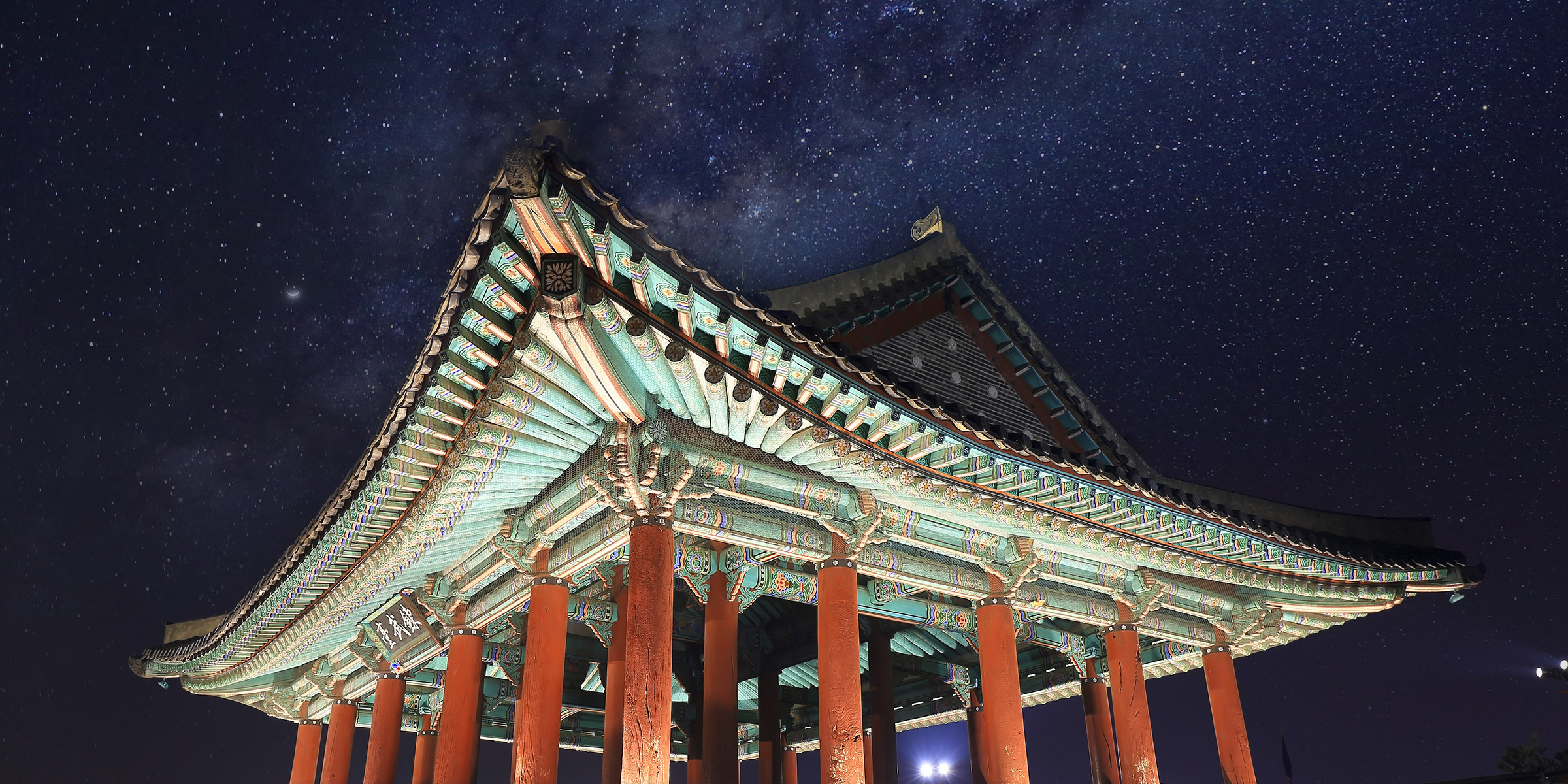Streaks of car lights in the night view and the crescent wall of Janganmun Gate in Hwaseong Fortress